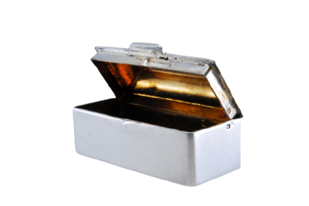 Caixa de comprimidos em prata lisa alteada e de forma retangular com tampa basculante.